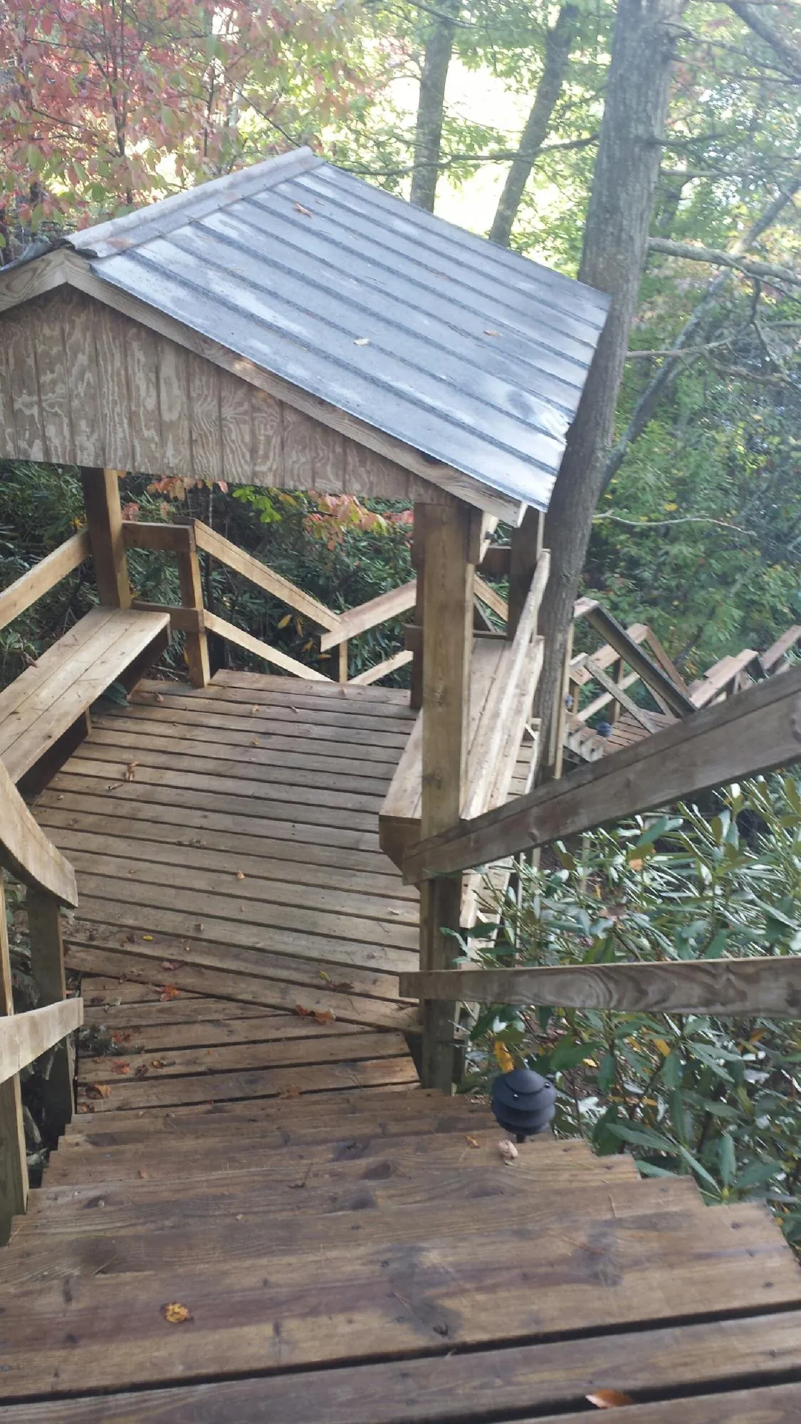 Metal roofed shelter over wooden steps on a wooded walkway — Skylight Repair & Installation work by our crew in Chillicothe